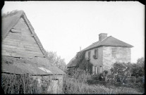 Femme posant dans un jardin sur le devant d'une maison de la campagne de Rosay-sur-Lieure (Eure).