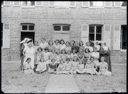 Groupe de jeunes filles encadrées de sœurs à cornettes, probablement une école catholique.
