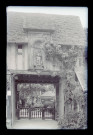 Porche sous arcade d'un manoir à pans de bois avec statue de Saint-Roch, probablement un hôtel.