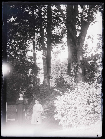 Femme et enfant dans un jardin.