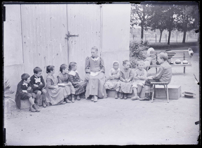 Melle Bonjean avec un groupe d'enfants dans un jardin.