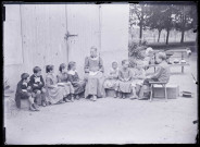 Melle Bonjean avec un groupe d'enfants dans un jardin.