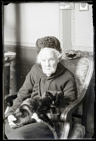 La mère de l'abbé Bretocq tenant son chat sur ses genoux.