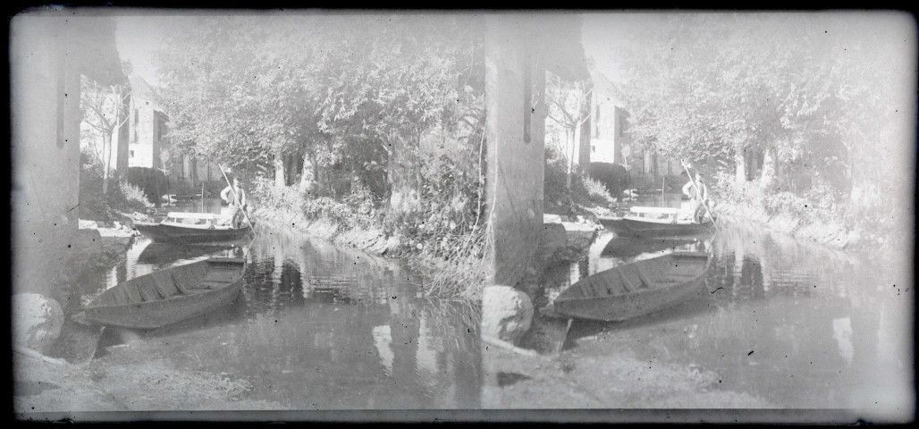 Homme à bord de sa barque à fond plat sur une rivière traversant la campagne bretonne.