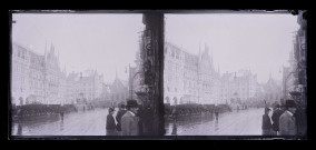Grande place animée avec calèches, rail de tramway et bâtiment monumental.
