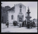 Villageois à la fontaine sur la place d'une église sicilienne.