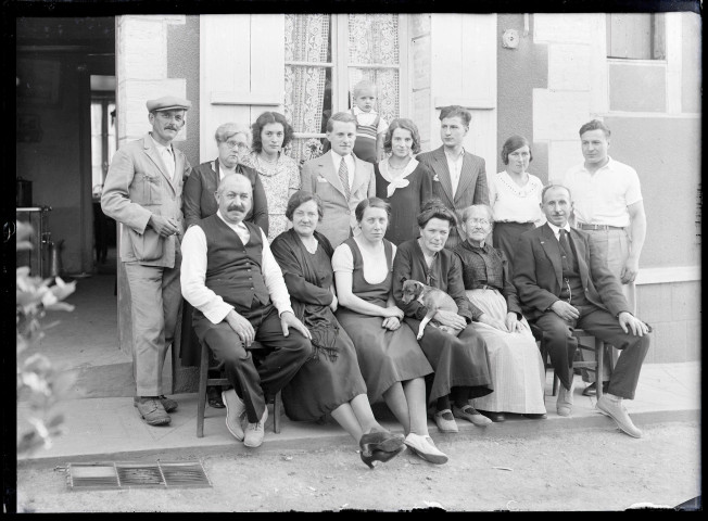 Famille Bretocq et amis posant devant une habitation de campagne.