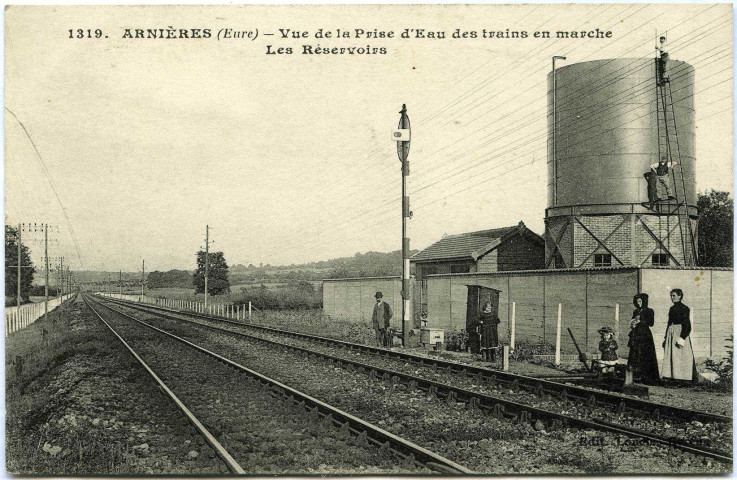 Arnières-sur-Iton. Vue de la prise d'eau des trains en marche - Les réservoirs.