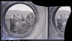 Vue d'une ville et de son minaret à travers un œil de bœuf.