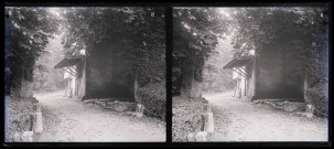Bâtiment en pierre et briquettes rouges et lavoir dans la campagne.