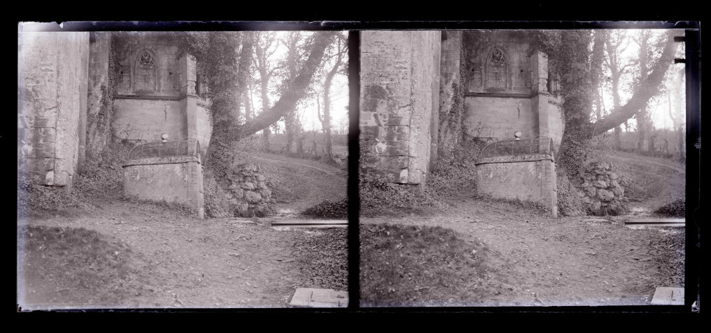 Fontaine à l'angle d'un édifice religieux en ruines dans la campagne.