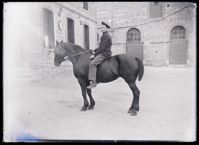 Militaire français à cheval dans la cour de la maison fermière d'Orgeville (Eure).