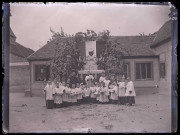 Ecclésiastique et enfants de chœur du Sacré-Cœur devant une habitation.