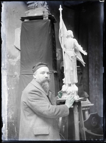 Artiste travaillant à la sculpture de la statue de Jeanne d'Arc dans les ateliers Charles Desvergnes.