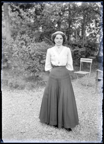 Jeune femme dans un jardin, probablement de Lourdes (Hautes-Pyrénées).