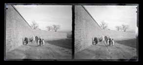 Bédouins et enfants sur un chemin remontant le long de rempart.