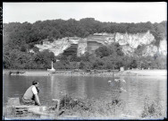 Jeune homme assis sur la rive de la Seine aux environs des ruines et vestiges de l'abbaye de Jumièges (Seine-Maritime).