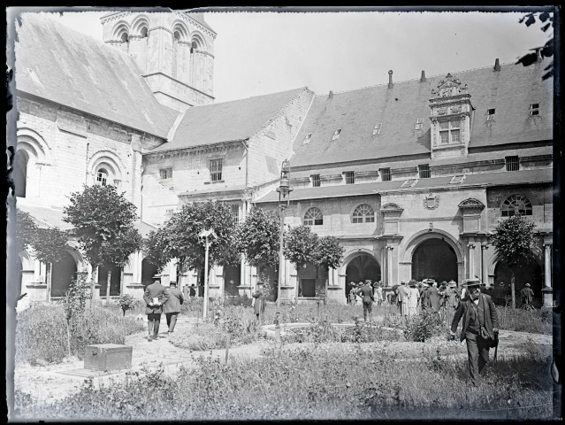 Hommes et femmes dans le jardin d'une église ou d'une abbaye.