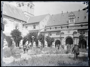 Hommes et femmes dans le jardin d'une église ou d'une abbaye.