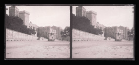 Esplanade avec statue au pied de remparts et de fortifications.