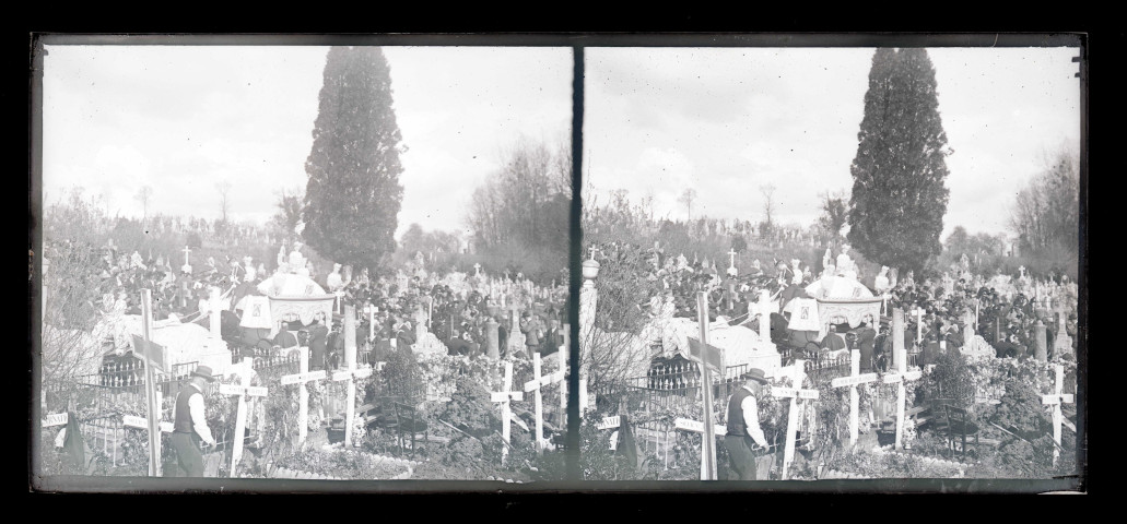 Cortège et corbillard dans un cimetière.