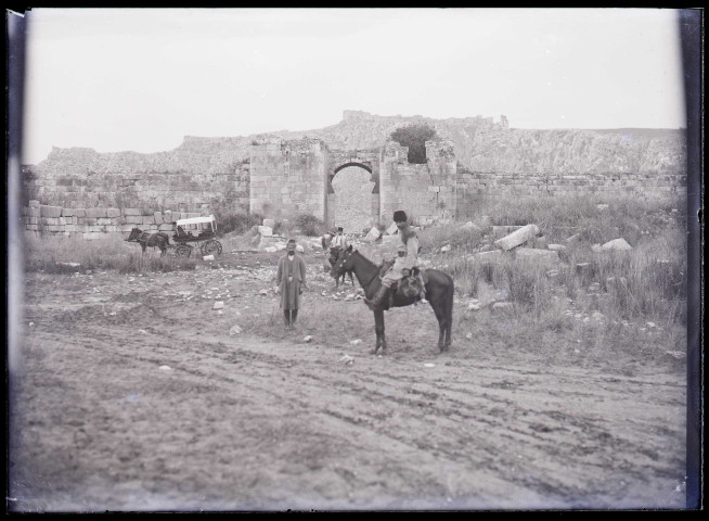 Porte et mur fortifiés en ruines.