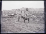 Porte et mur fortifiés en ruines.
