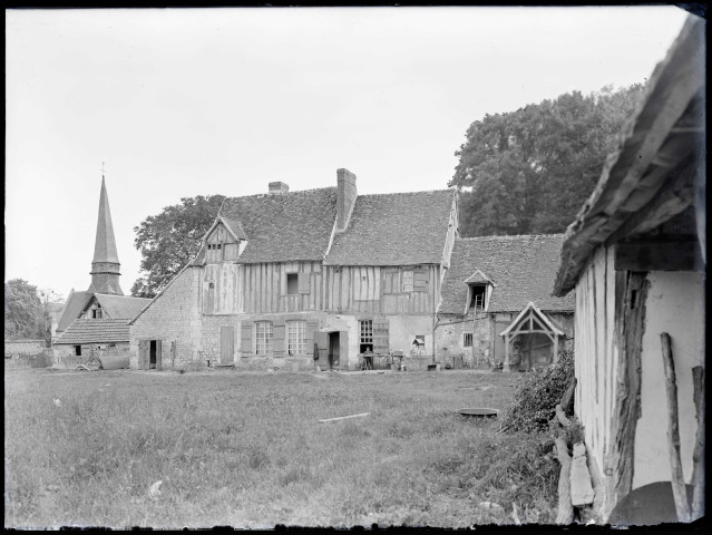 Ferme à colombages et clocher d'église de la campagne normande.