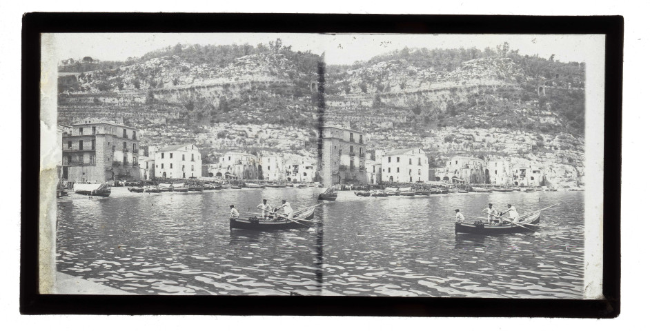 Marins à bord de leur barque dans le port d'une ville italienne.