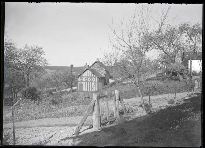 Vue de l'arrière d'une maison et de son potager dans la campagne de Rosay-sur-Lieure (Eure).