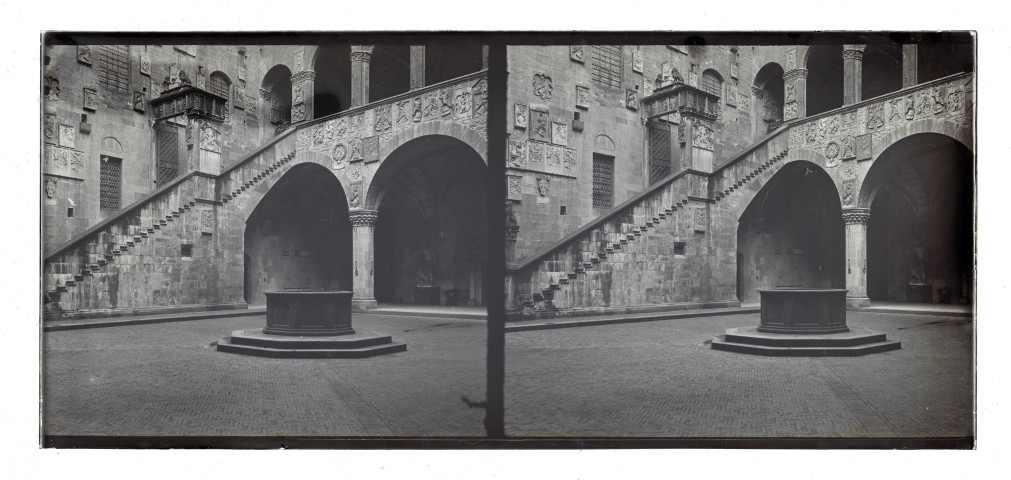 Cour intérieure ornementée avec balcon, puits et statues.