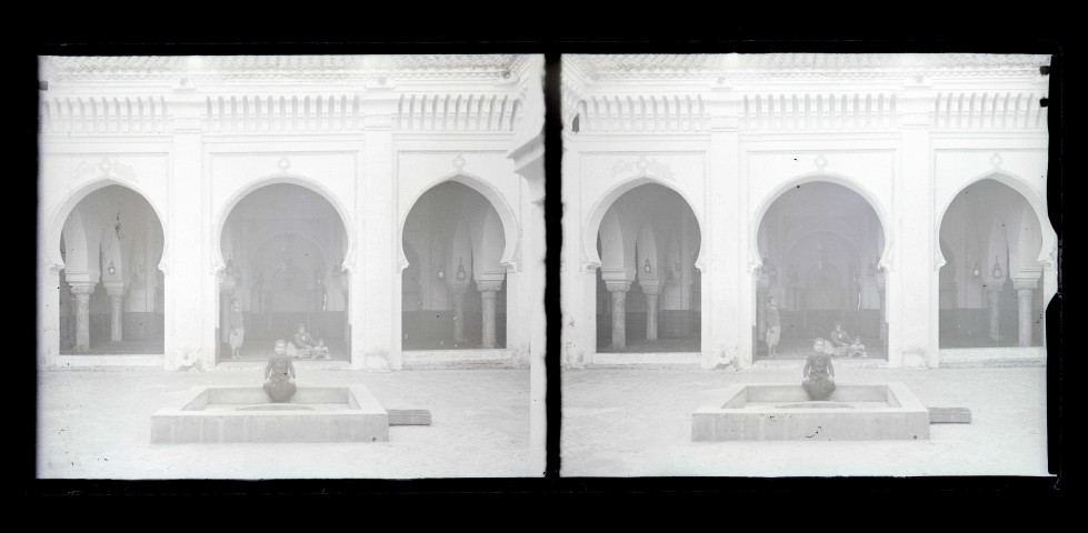 Cour intérieure à arcades et fontaine d'une habitation traditionnelle algérienne.