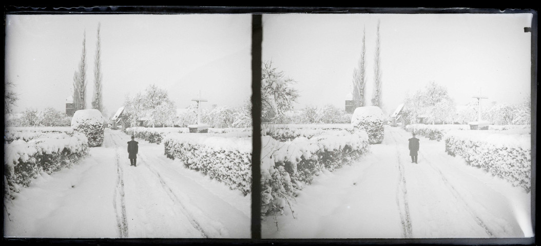 Jeune homme en tenue militaire prés d'un calvaire de campagne sous la neige.