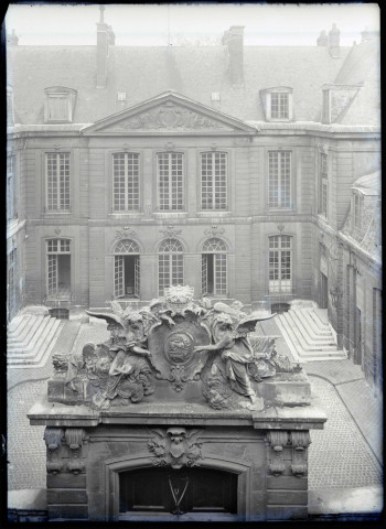 Vue sur le fronton et la cour intérieure d'un hôtel particulier ou d'un bâtiment administratif.