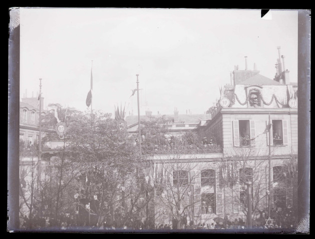 Défilé de troupes militaires devant la façade d'un bâtiment officiel.