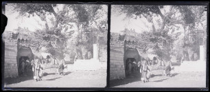Hommes et femmes avec leurs montures devant de la porte de la ville Biredjik (Turquie).