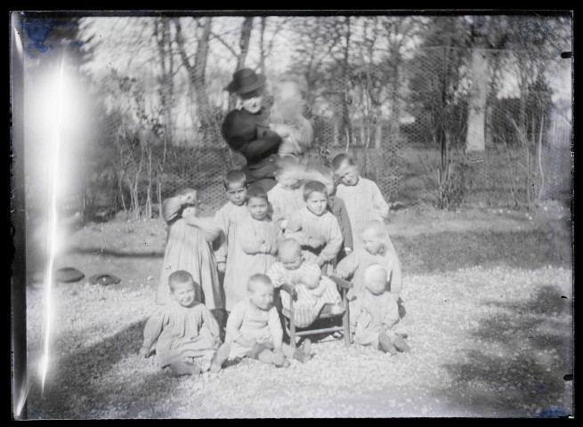 Melle Bonjean avec un groupe d'enfants dans un jardin.