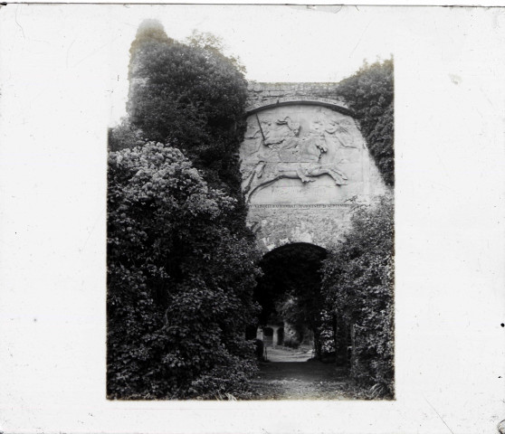 Porte d'enceinte fortifiée avec sculpture en pierre taillée remémorant le combat d'Arques du château d'Arques-la-Bataille (Seine-Maritime).