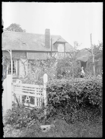 Femme dans le potager devant sa maison « Les Reines-Claudes ».