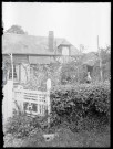 Femme dans le potager devant sa maison « Les Reines-Claudes ».