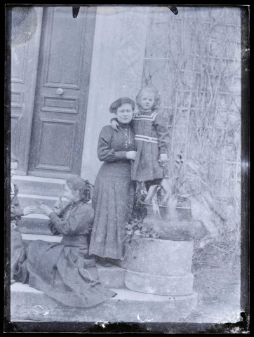 Femmes et enfant sur le perron d'une habitation.
