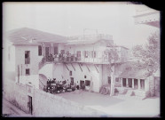 Groupe d'enfants et frères capucins dans la cour d'un bâtiment.
