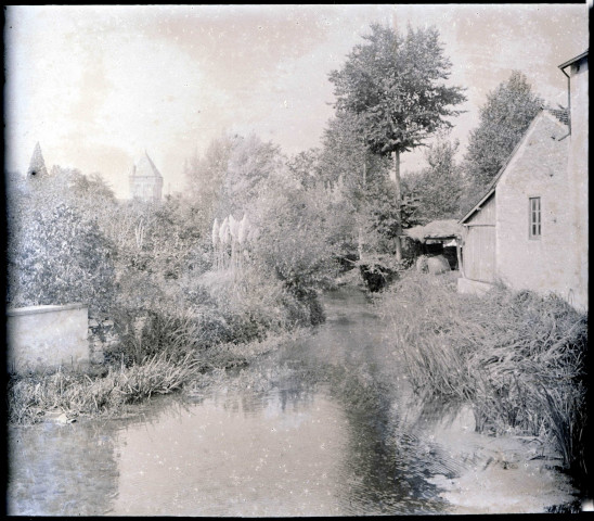 Rivière traversant la campagne normande, au loin une tour clocher.