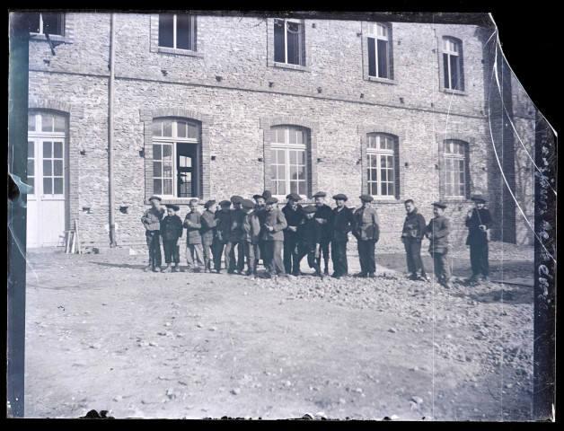 Groupe de jeunes garçons dans la cour d'un bâtiment lors des trois derniers jours de février 1899.
