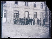 Groupe de jeunes garçons dans la cour d'un bâtiment lors des trois derniers jours de février 1899.
