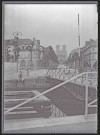 Vue d'un pont menant à une grande avenue commerçante, avec en perspective la cathédrale de Reims (Marne).