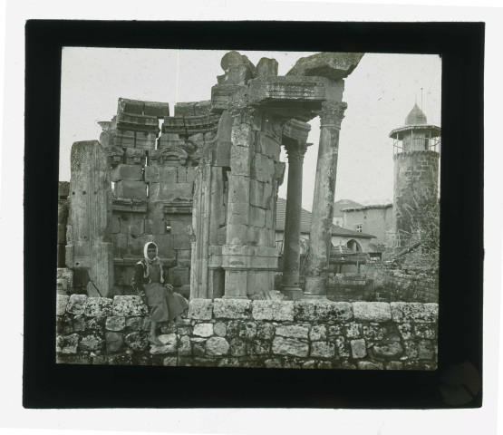 Ruines et vestiges de temple, à l'arrière plan un minaret.