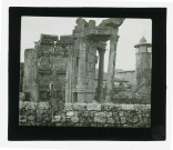 Ruines et vestiges de temple, à l'arrière plan un minaret.