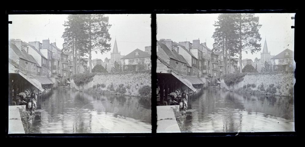 Femmes au lavoir dans une rivière traversant un village.