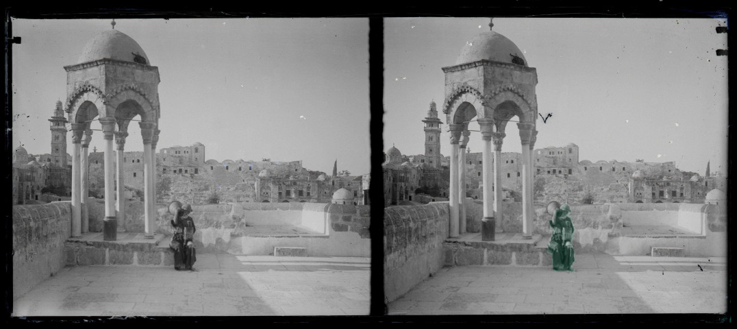 Porteuse d'eau sur l'esplanade d'une mosquée avec mihrab et minaret en arrière plan.